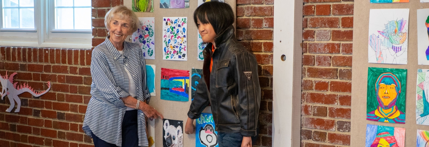 Student and grandparent pointing to artwork